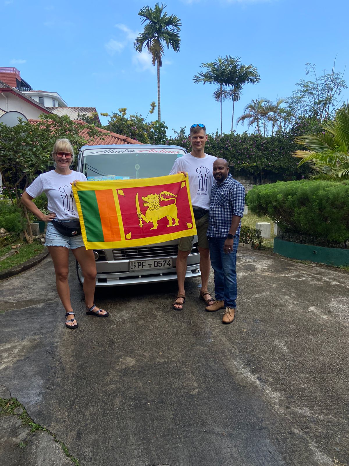 Travellers displaying a Sri Lankan flag beside their vehicle